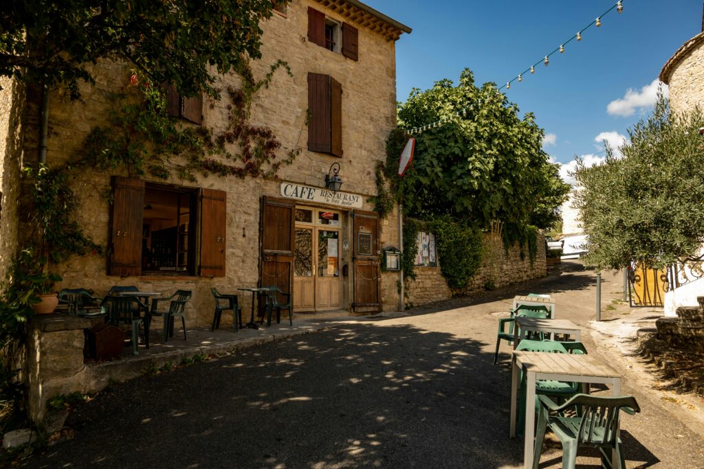 Terrasse de café ensoleillée dans un village de Provence, ambiance typique du sud de la France. Sunny café terrace in a Provençal village, capturing the relaxed southern French lifestyle.