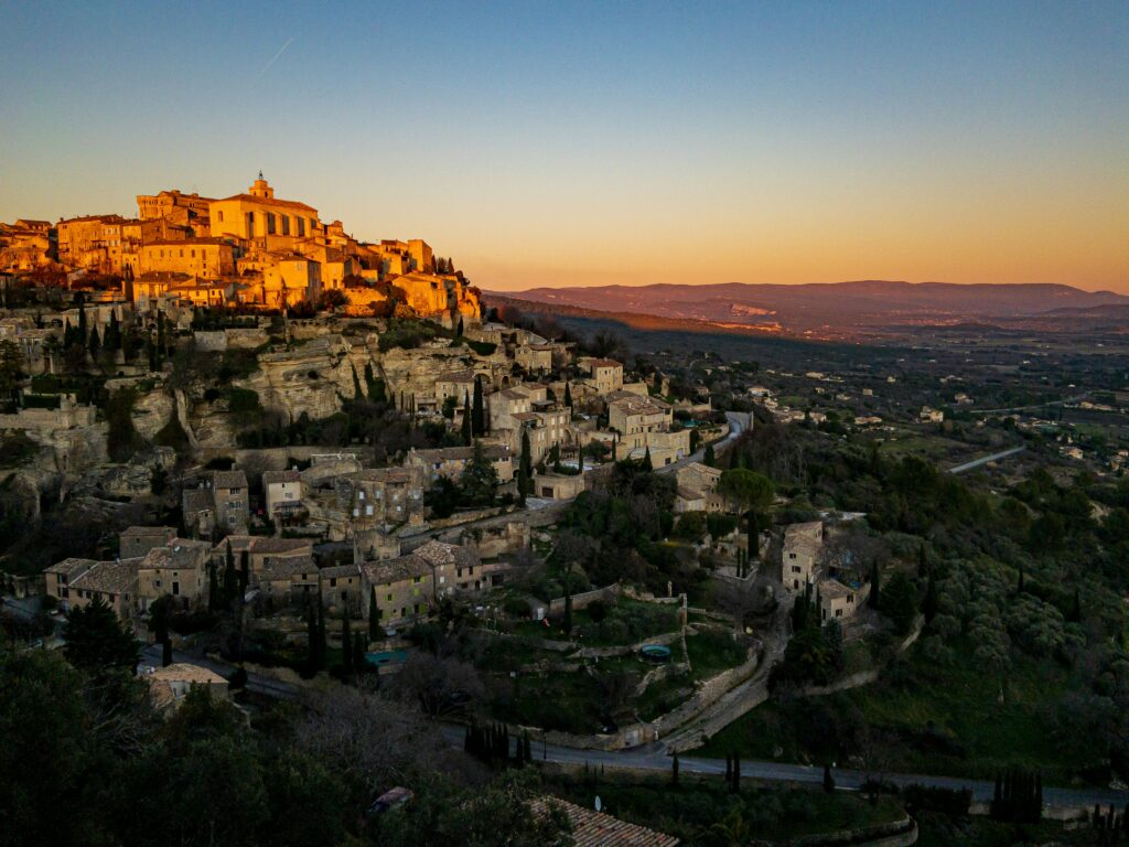 Vue panoramique sur Gordes au coucher du soleil, l’un des plus beaux villages de Provence. Panoramic sunset view of Gordes, one of the most beautiful villages in Provence.