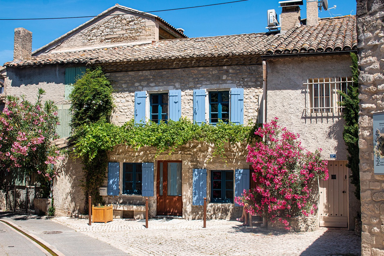 Maison en pierre fleurie à Saint-Rémy-de-Provence, typique des villages du sud de la France. Charming stone house with flowers in Saint-Rémy-de-Provence, typical of southern French villages.